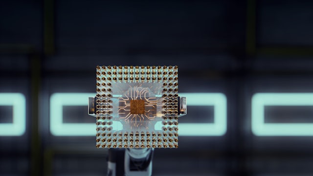 Computer screens displaying colorful graphs and data visualizations in a dark room with glowing blue light.