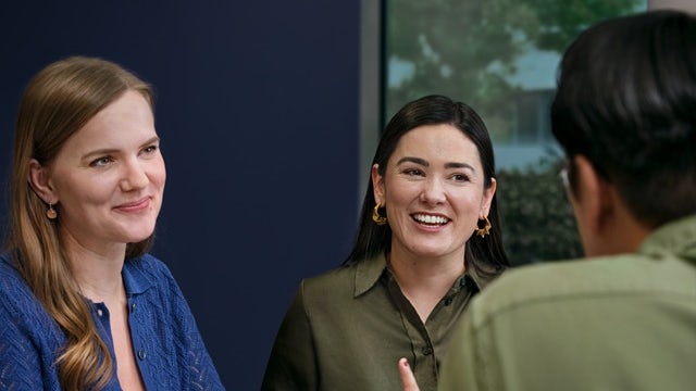 Two women having a conversation with a man.