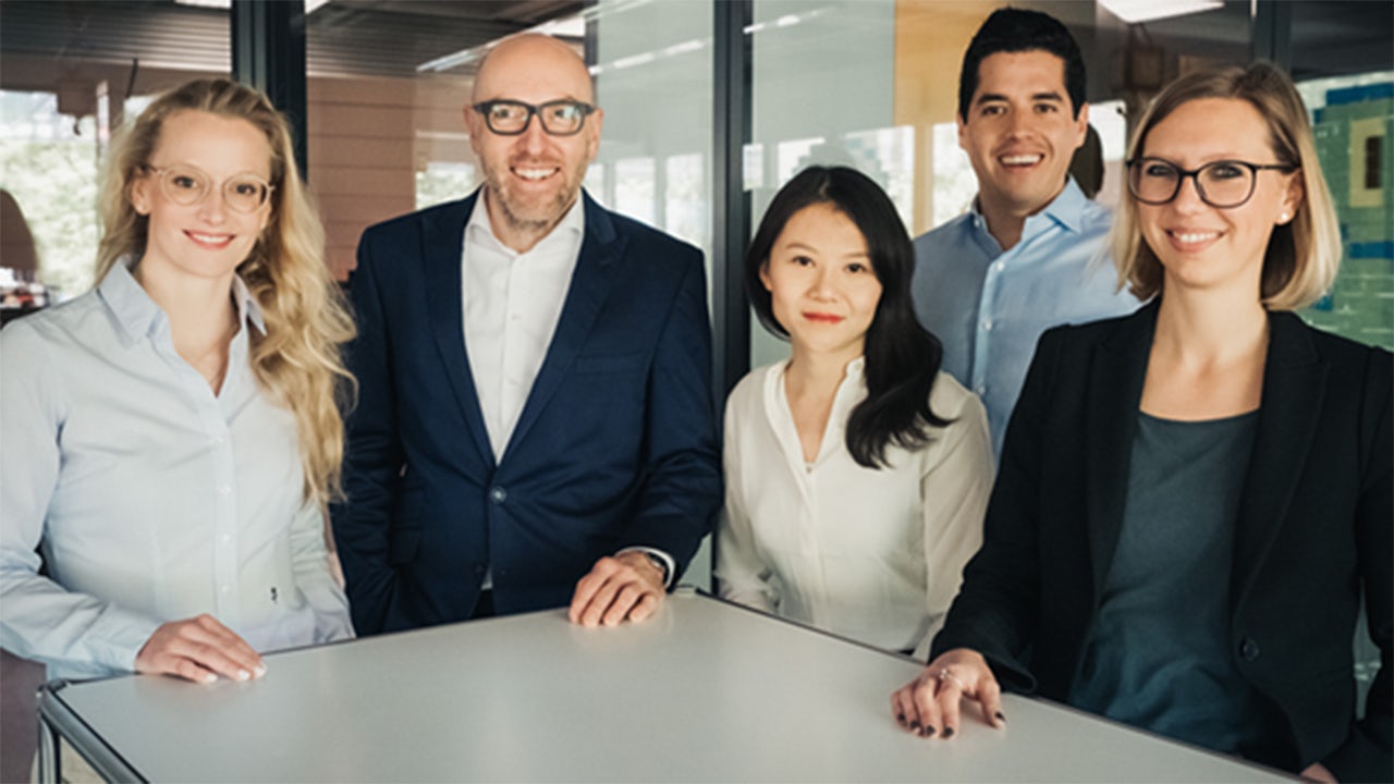 A group of people in business attire standing together for a photo.