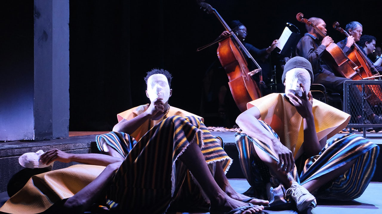 A person is standing in front of a Siemens building with a banner that reads 