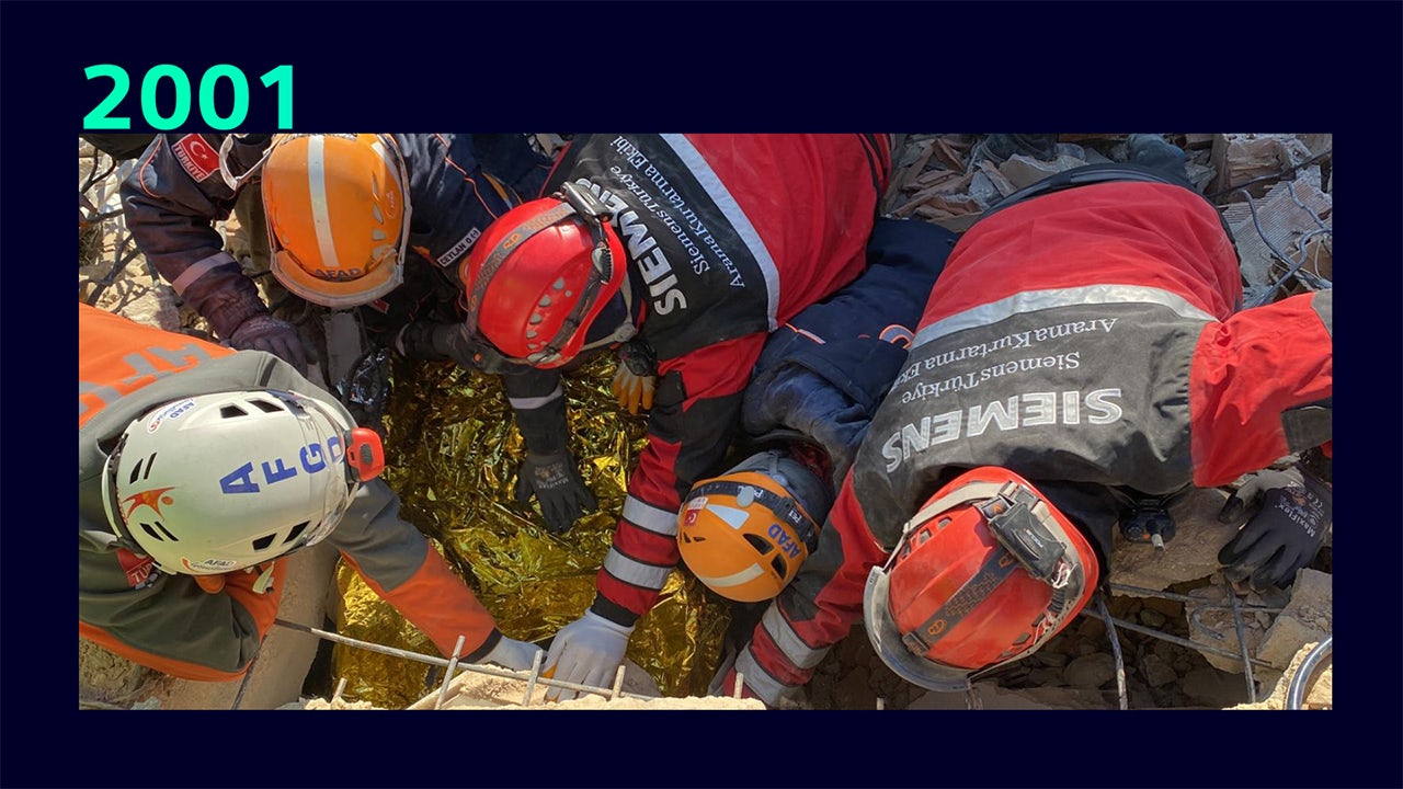 A person with a caring expression holding a baby in their arms.