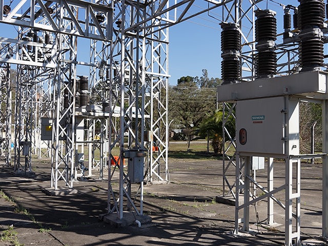 Industrial electrical equipment with cylindrical components on a metal frame against a blurred background