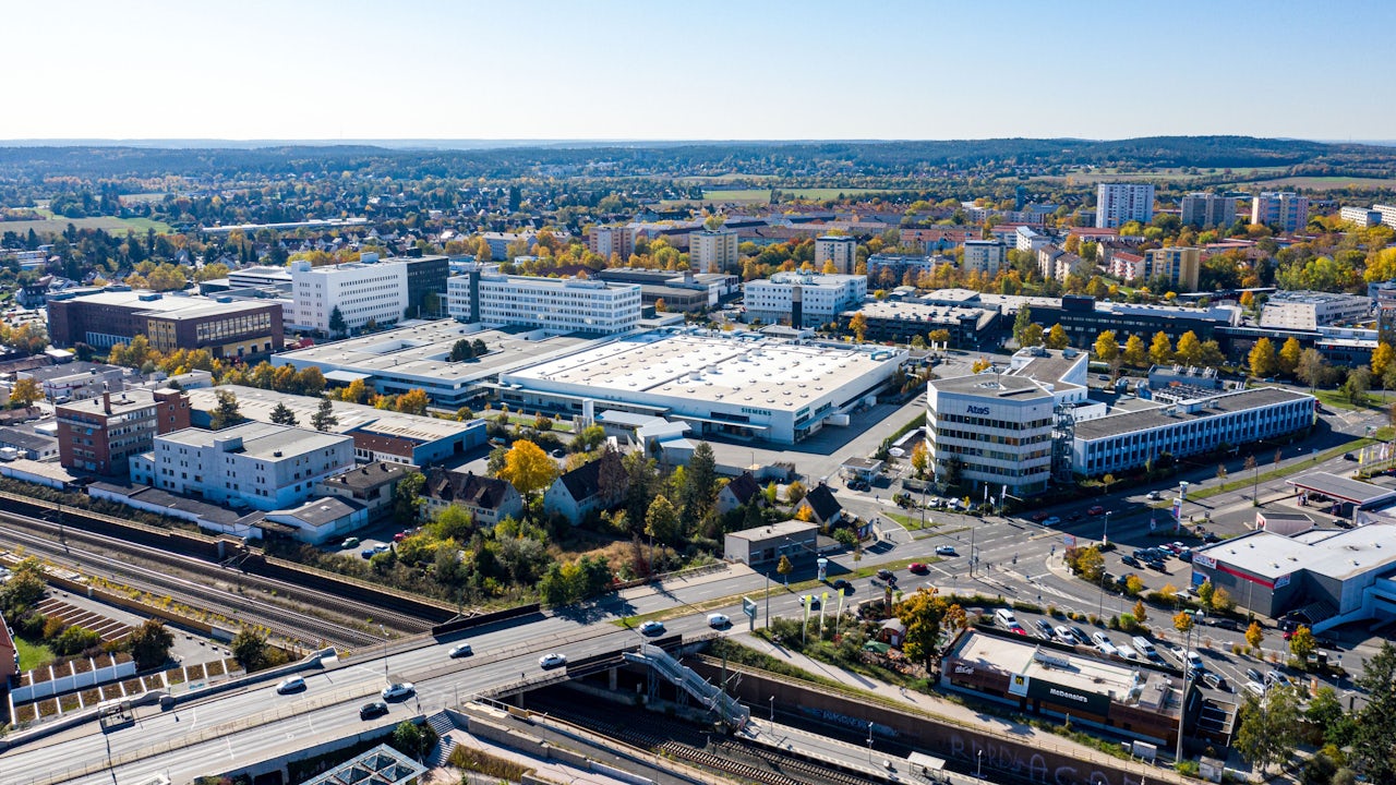 A Siemens facility with a large building and a group of people standing in front of it. 