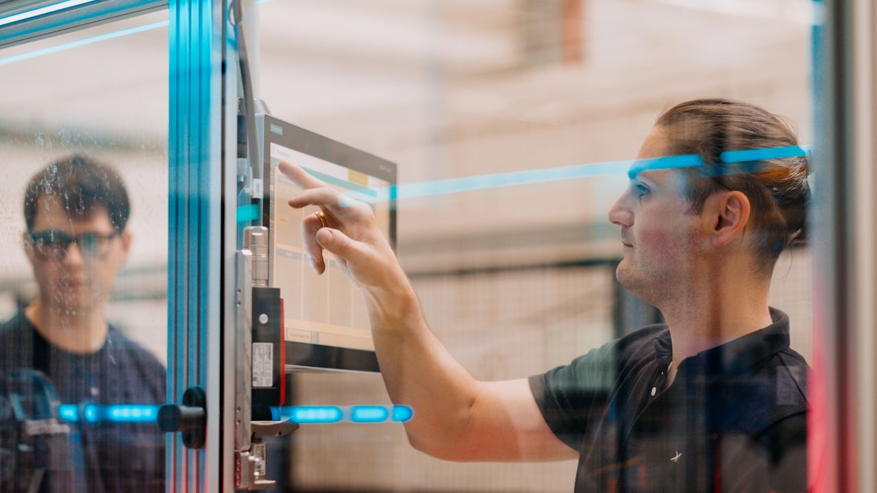 Siemens industrial copilot with a robotic arm and a digital interface.