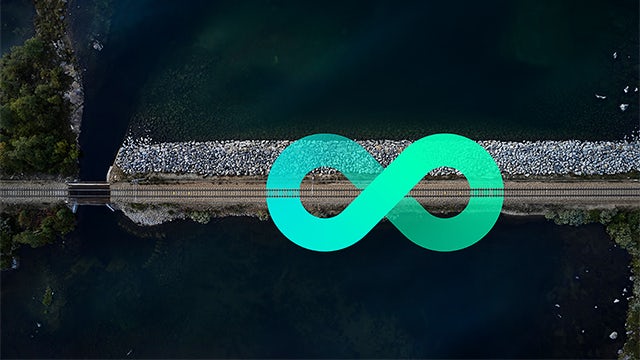 Aerial view of railway by water with teal infinity symbol overlay