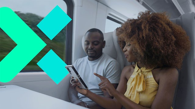 Couple on train looking at smartphone, teal logo overlay