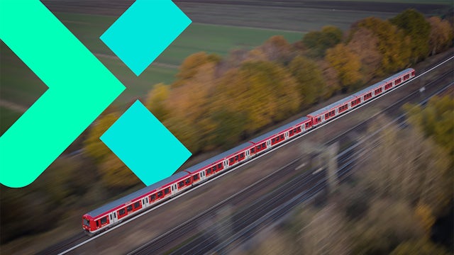 Red train speeding through autumn landscape, teal logo overlay.