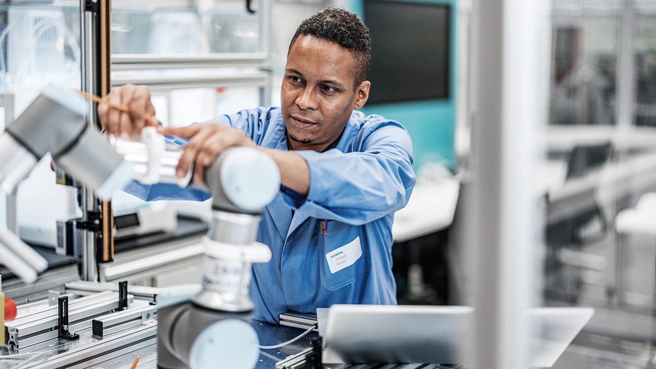 The image shows a group of people working together on a project in an office setting.
