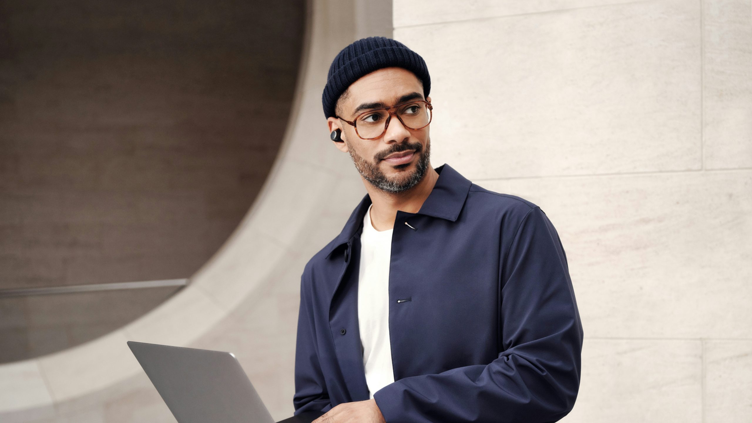 Person wearing hard hat and safety vest looking at industrial equipment in a factory setting