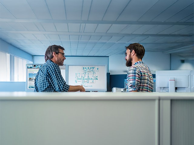 Two people working together looking at a computer screen with visualization of water systems.