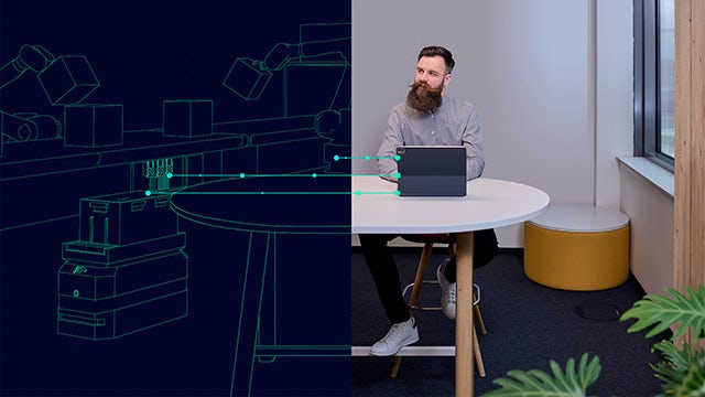 A man uses a tablet to manage a digital twin of a shop floor, illustrating how IT/OT integration solves data challenges.