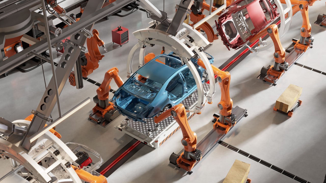Robotic arms are used to assemble a car a factory floor.