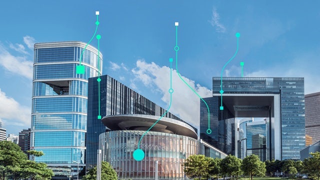 A building with a modern architectural design, featuring glass windows and a sleek exterior, set against a blue sky.