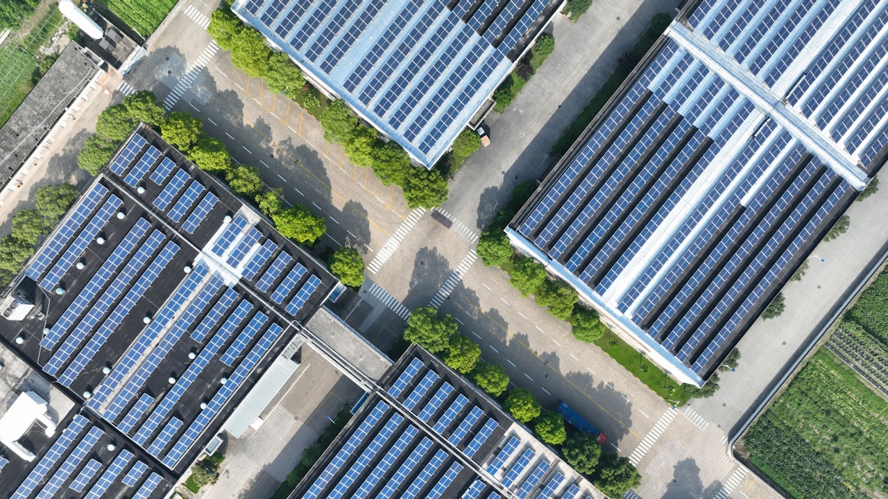 Aerial view of battery manufacturing facility with robotic arms and conveyor belts