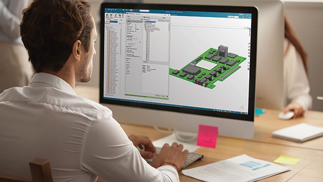 Engineer sitting behind a computer working in a model with Solid Edge Electrical Design.