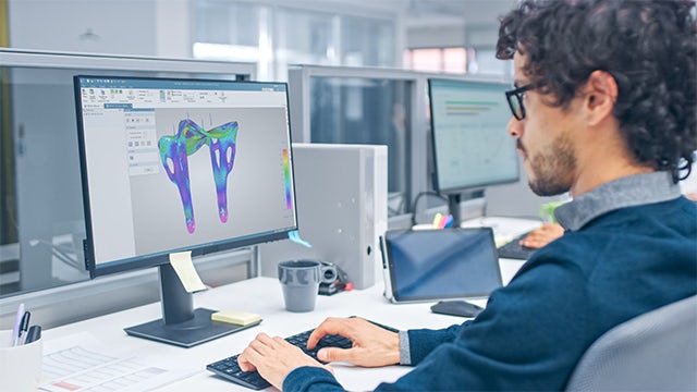 Engineer sitting behind a computer performing a stress analysis in Solid Edge.