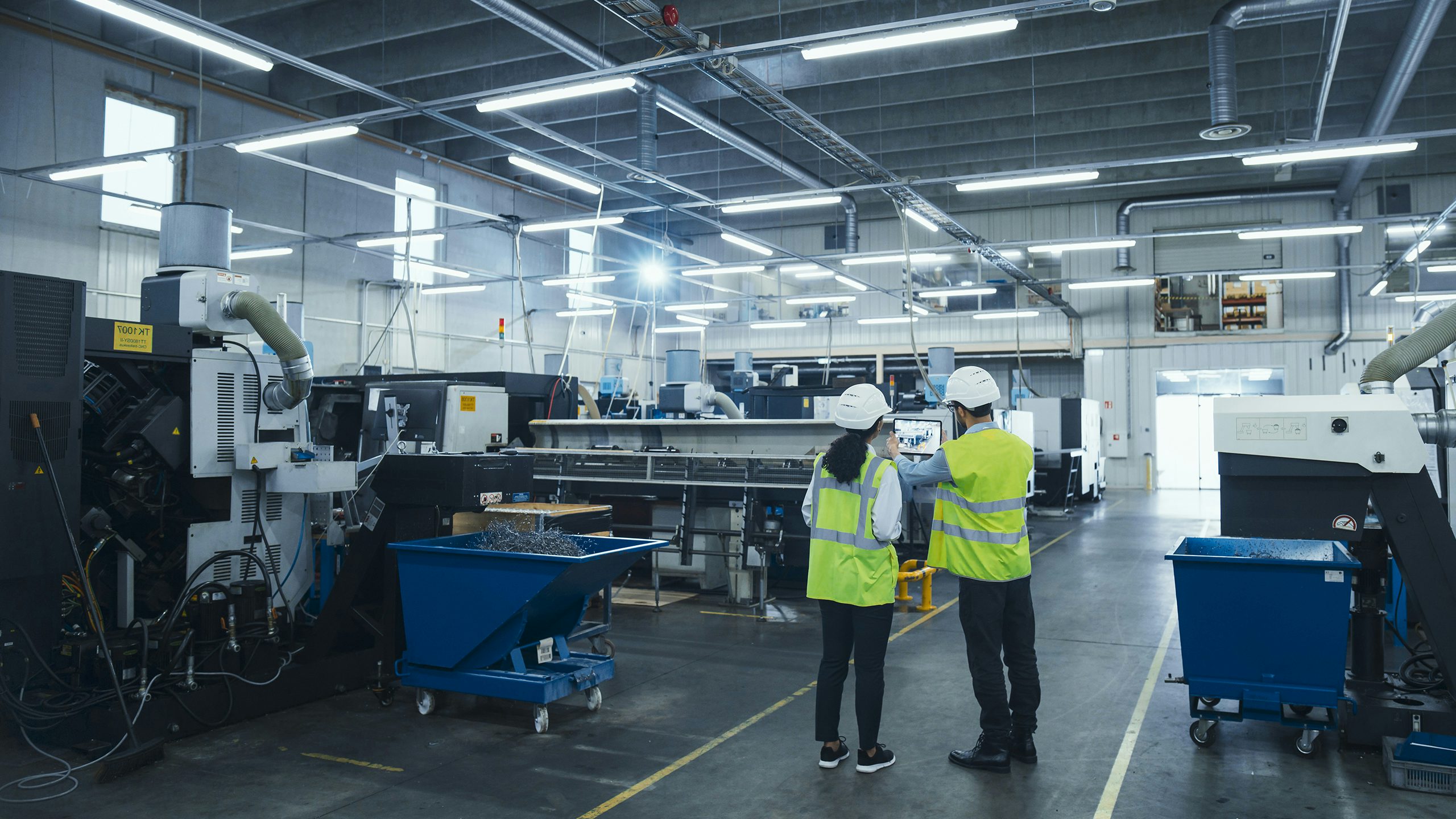 Two employees wearing safety gear in a factory.