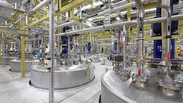 Laboratory glassware with colorful liquids on a reflective surface