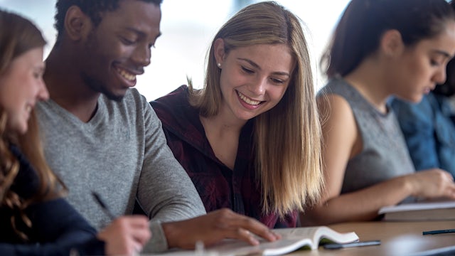 Students looking at book.