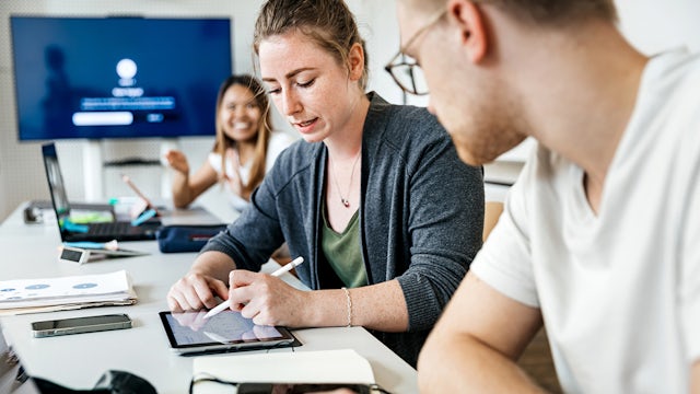 Students looking at tablet.