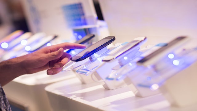 Person touching a cellphone at a store.