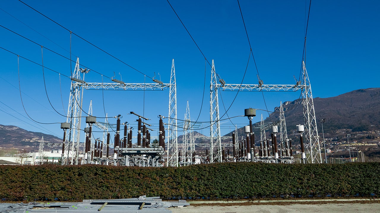 Animation showing electricity flowing from power lines through a control building into a city.