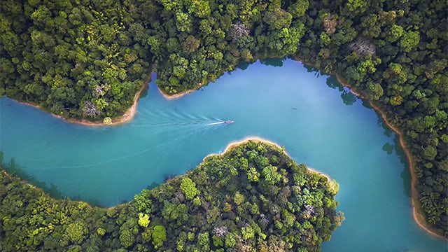 Image of a blue river with a boat moving through it.
