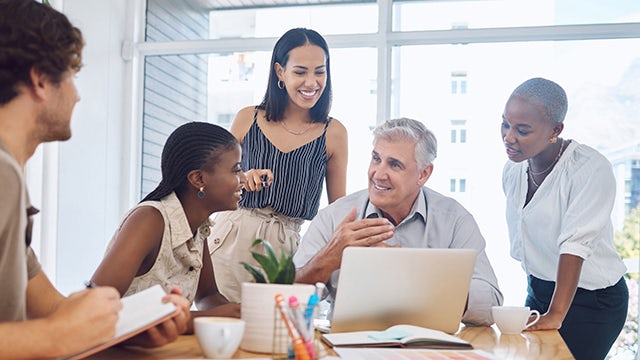 A group of people in an office setting are working together on a project.