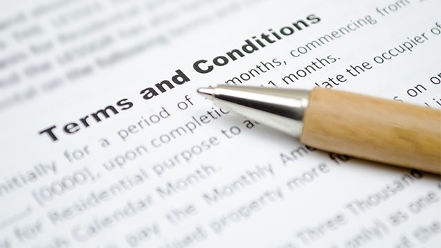 Close-up of a pen pointing at a document titled “Terms and Conditions.”