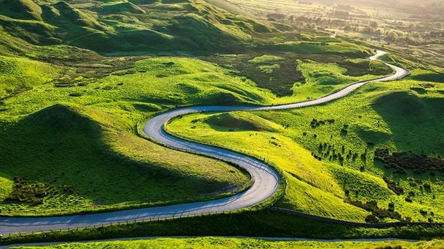 Roadway winding through green hills.