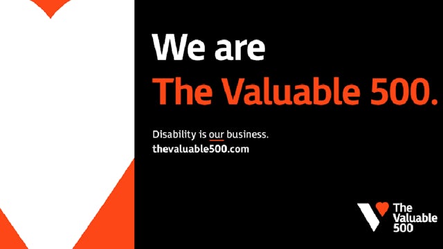 A group of people standing together in front of a building with a banner that reads "The Valuable 500".