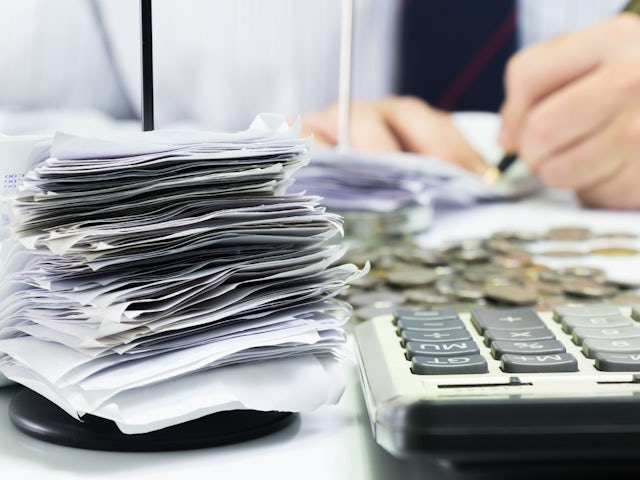A person is standing in front of a white wall with a blue and white sign.