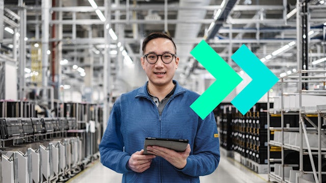 Man smiling with tablet in factory