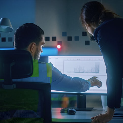 Group of diverse people smiling and collaborating around a laptop in an office setting