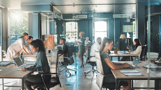 A group of office worker sitting at their desks and working on projects.