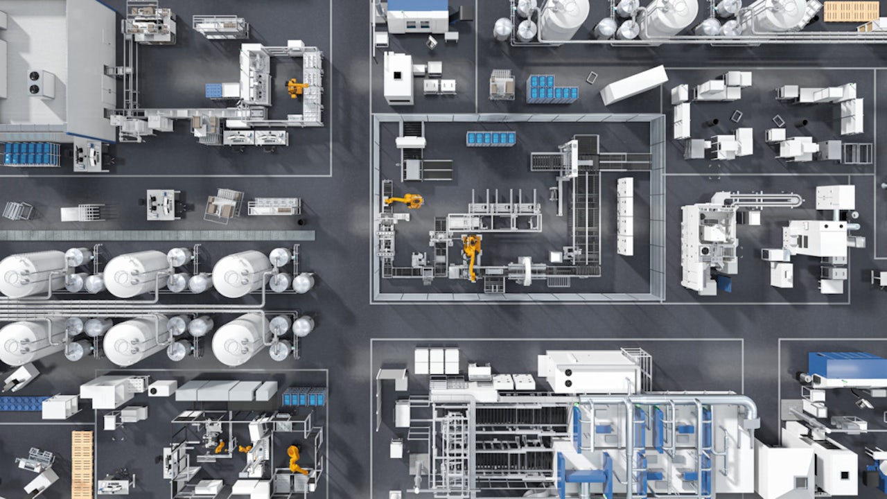 A person is standing in front of a large screen displaying a graph with a blue line and a red line.