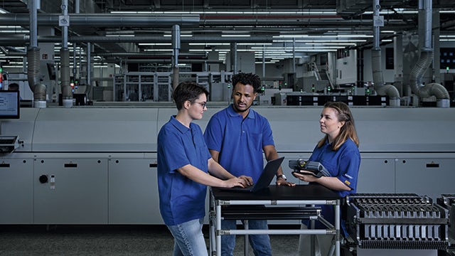 The image shows a group of people in a meeting, discussing work-related topics.