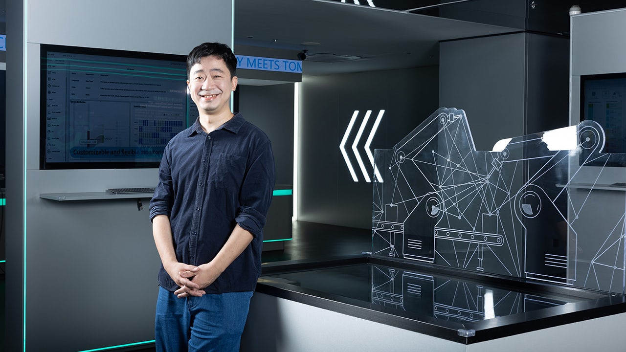 A workflow canvas with a factory setting and a person explaining the process.